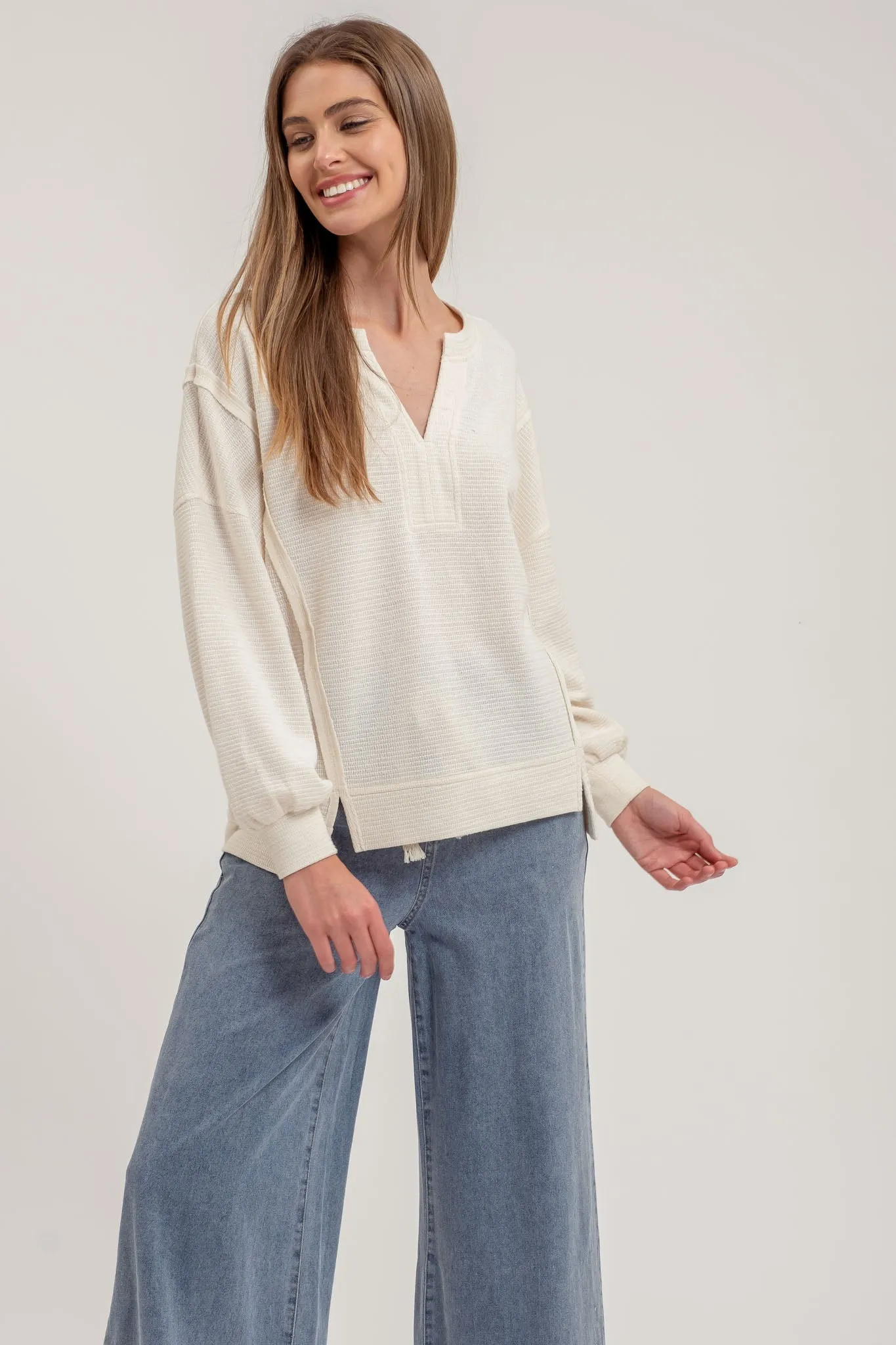 SPLIT NECK EXPOSED SEAM LONG SLEEVE KNIT TOP